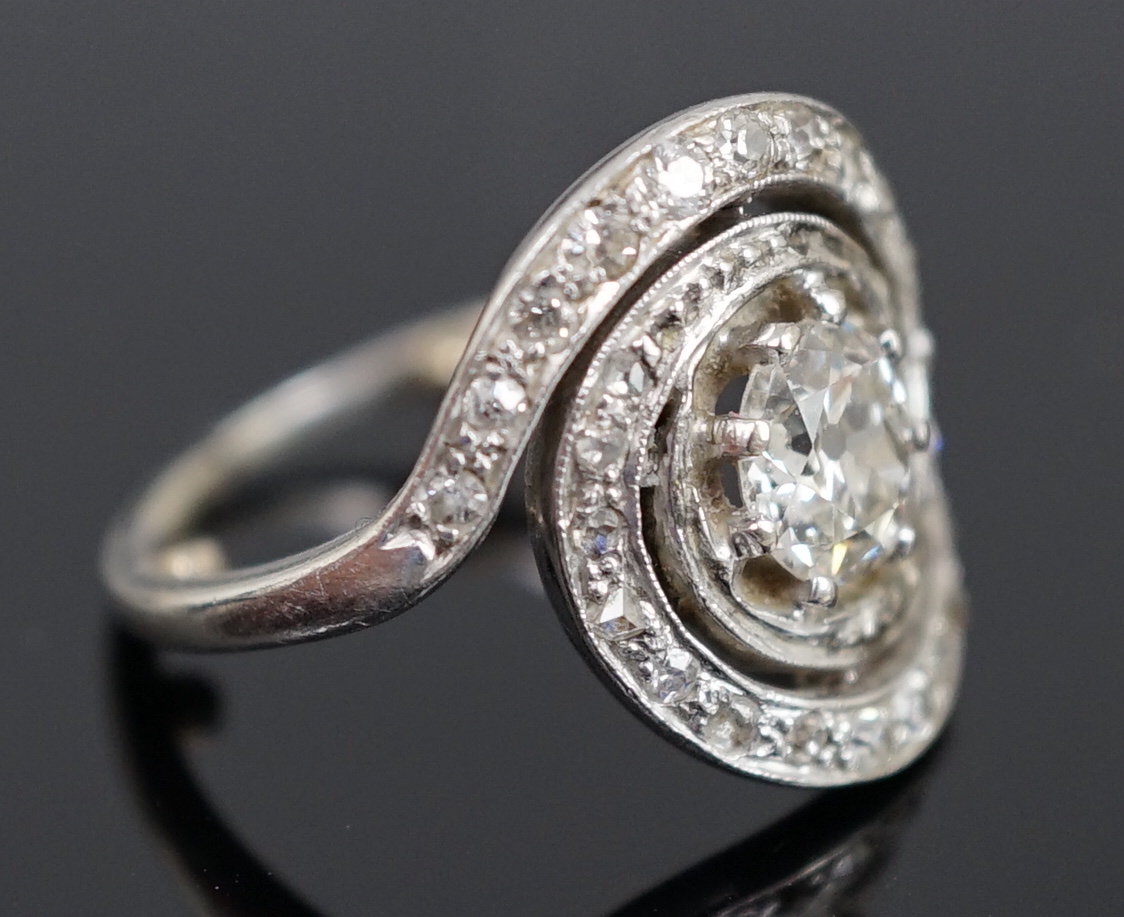 A mid 20th century platinum and diamond cluster set ring, of spiralling design